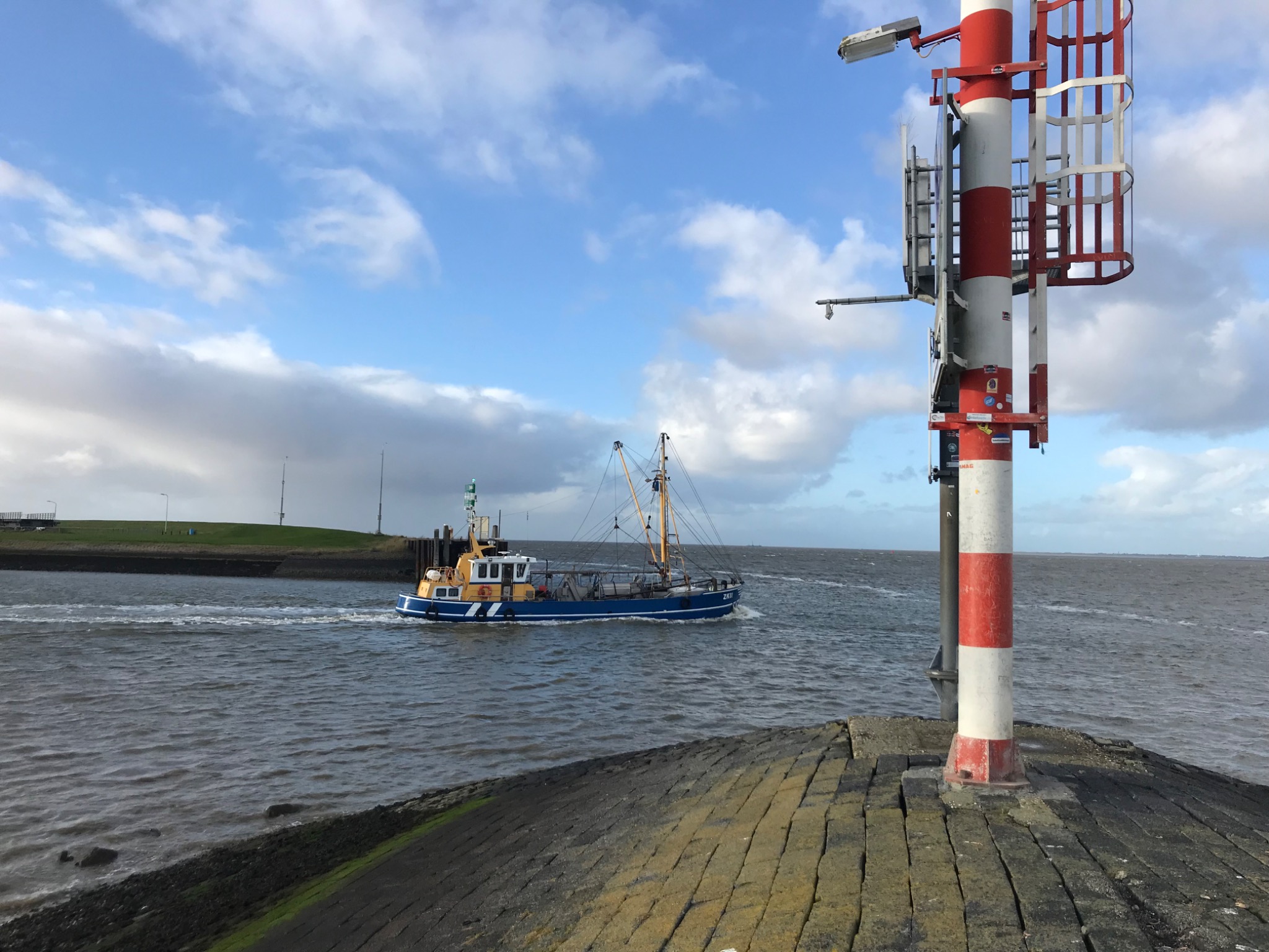 Fischereiboot und Leuchtturm am Wasser